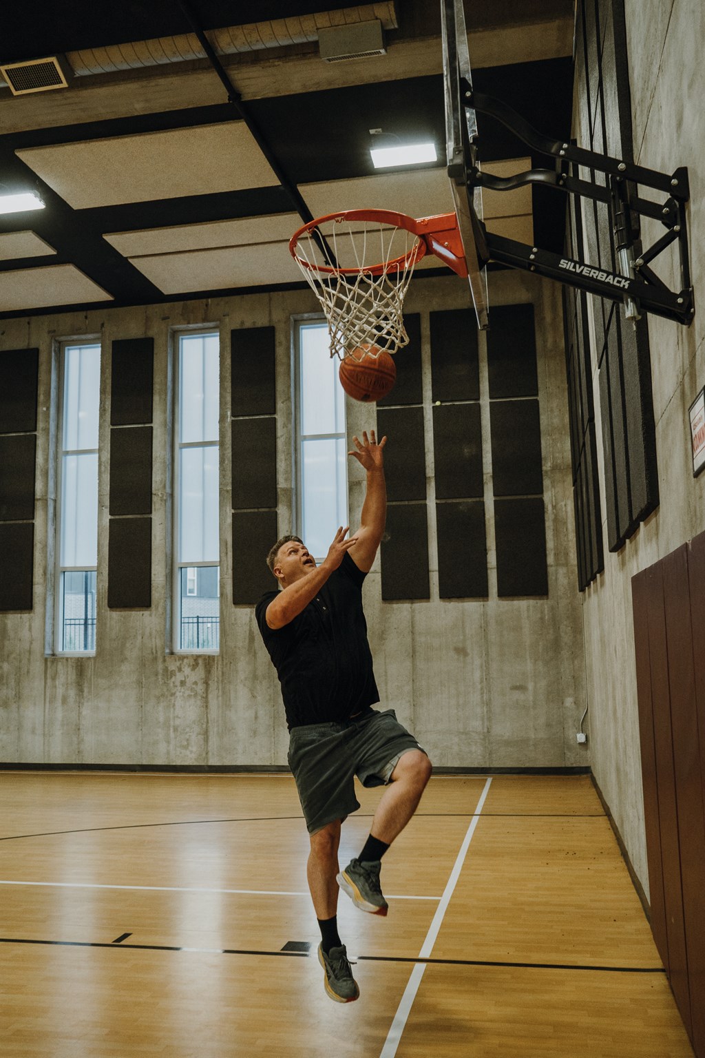 a man dunking a basketball on a hoop in a basketball court