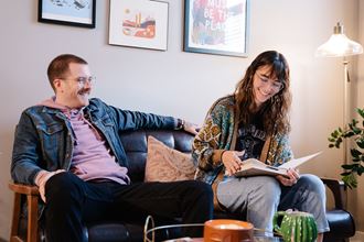 a man and a woman sitting on a couch in a living room