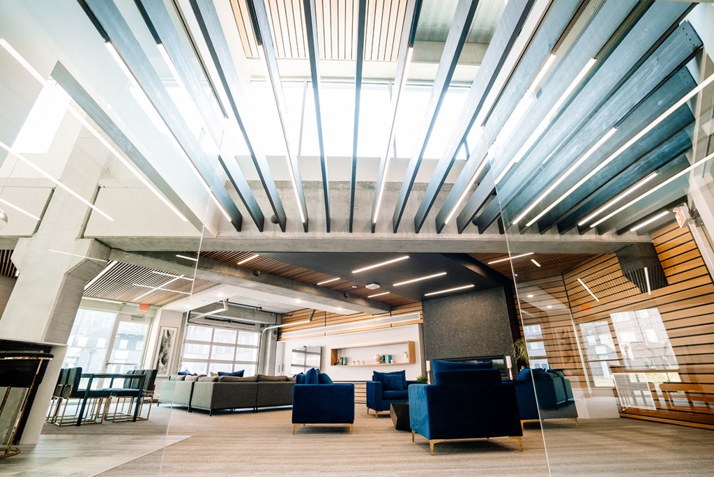 the lobby of a building with blue couches and chairs