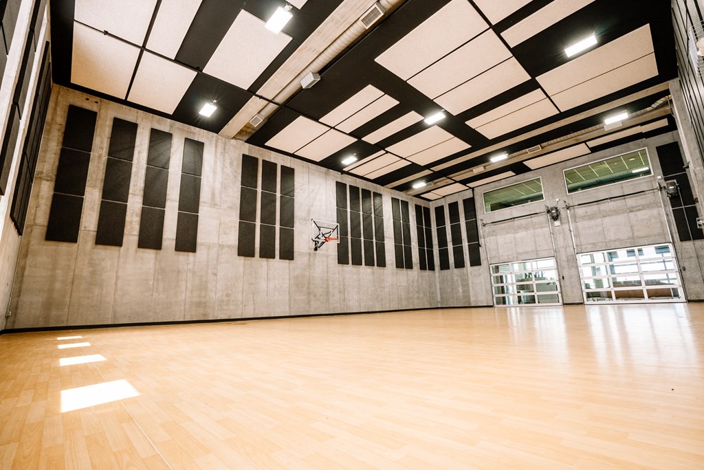 an empty gym with a wooden floor and a large window