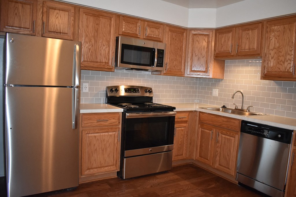 a kitchen with stainless steel appliances and wooden cabinets