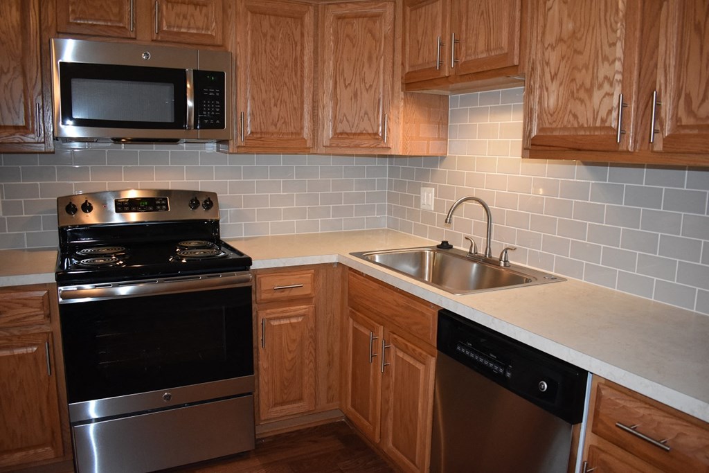 a kitchen with wooden cabinets and stainless steel appliances