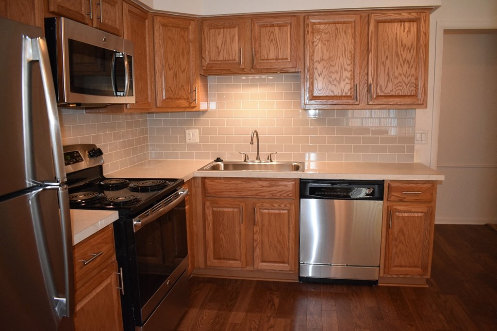 a kitchen with wooden cabinets and stainless steel appliances