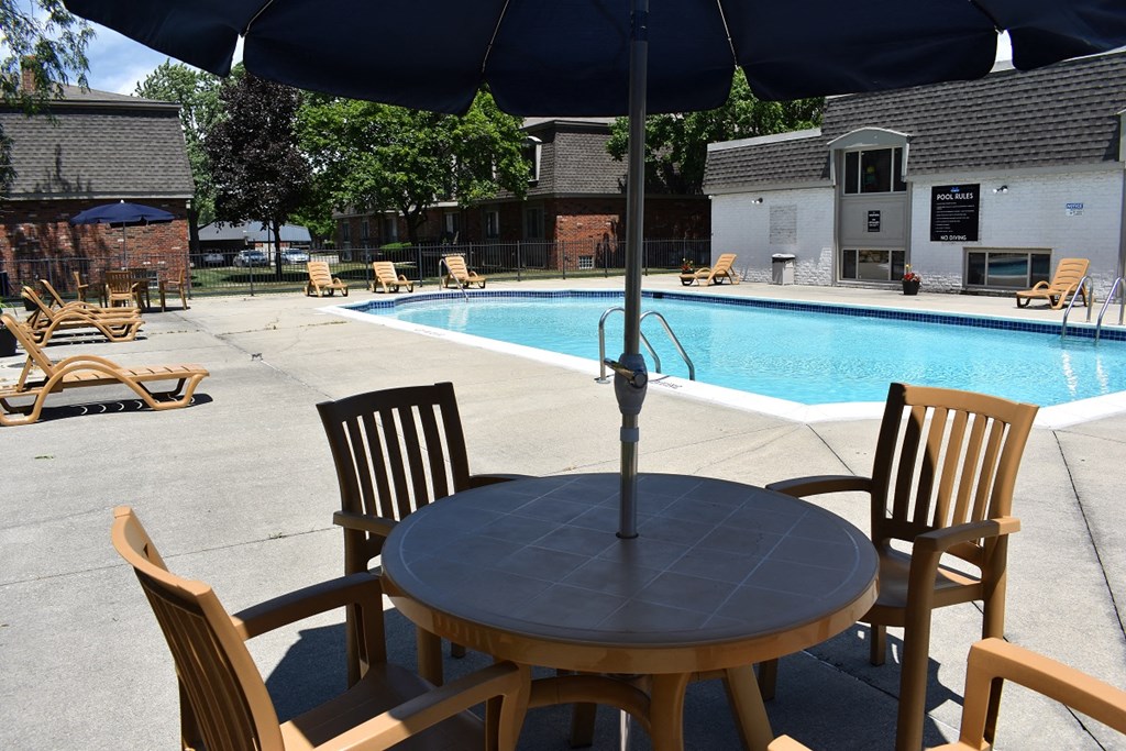 a table and chairs next to a swimming pool