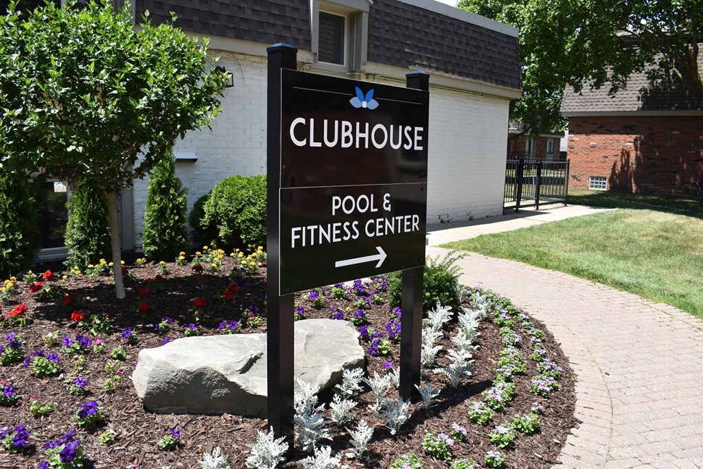 a sign for a pool and fitness center in front of a house