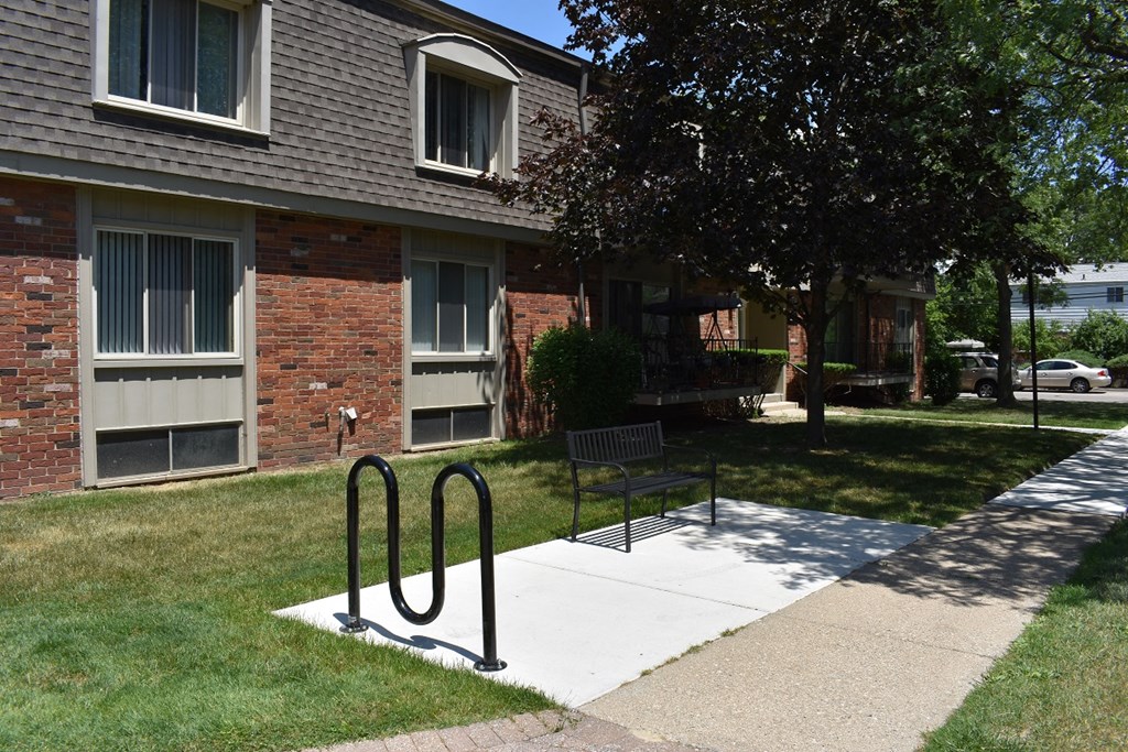 a bench on a sidewalk in front of an apartment building
