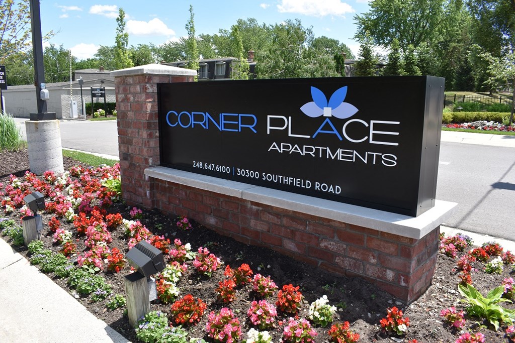 a sign for center place apartments in front of a flower garden