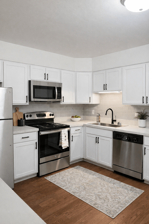 A kitchen with white cabinets and stainless steel appliances.