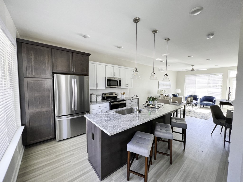 a large kitchen with stainless steel appliances and a marble counter top