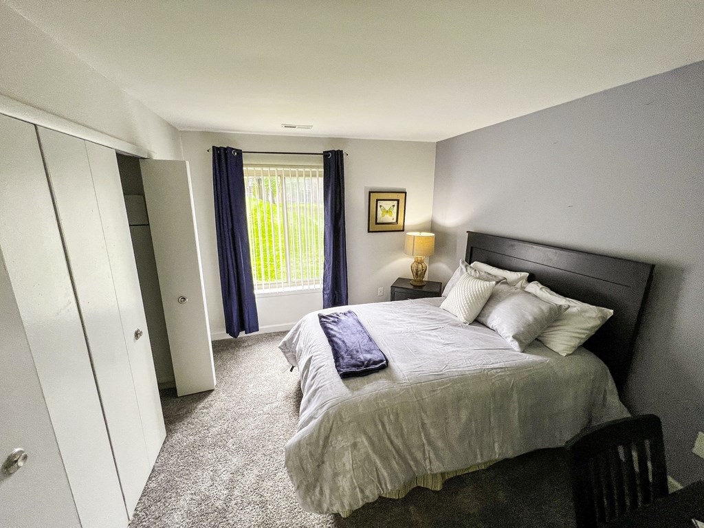 a bedroom with a large bed and a window