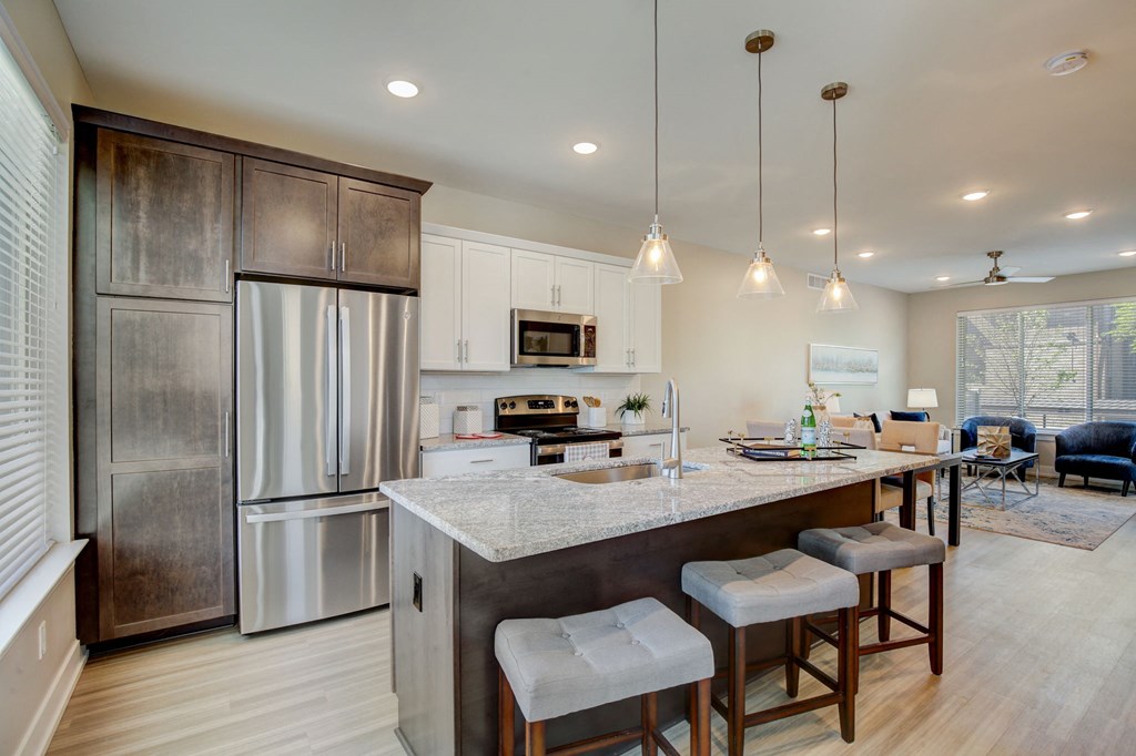 a kitchen with a large island with three stools