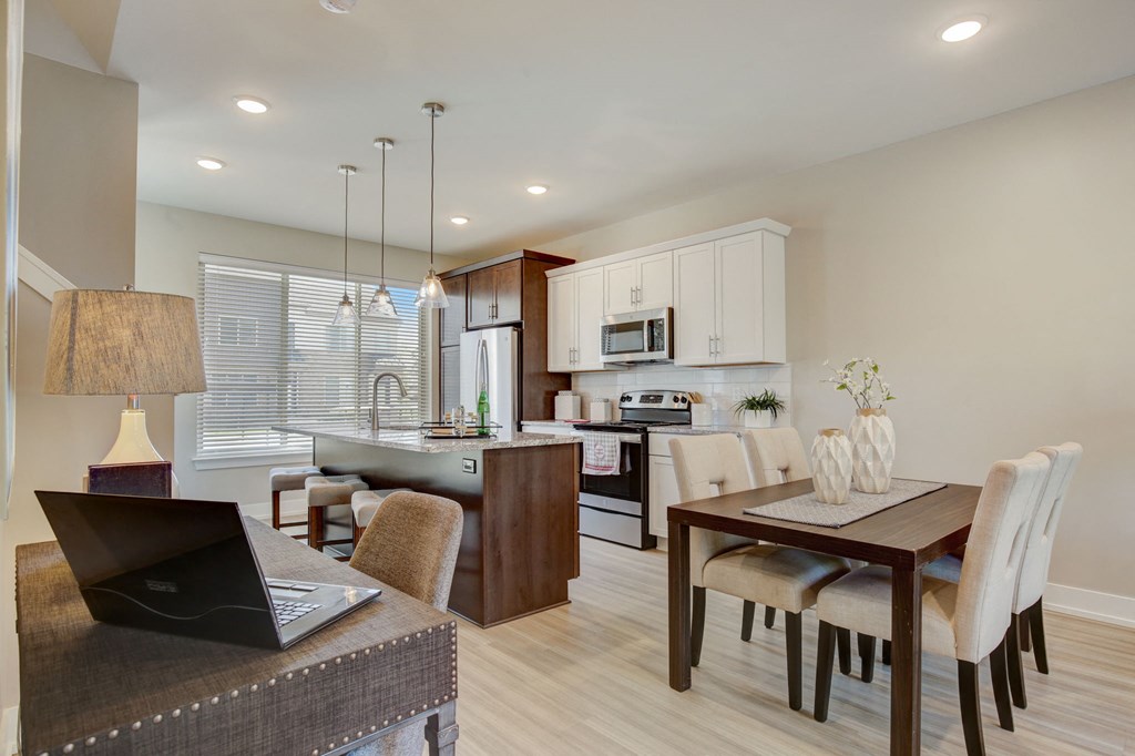 a kitchen and dining room with a laptop on a table
