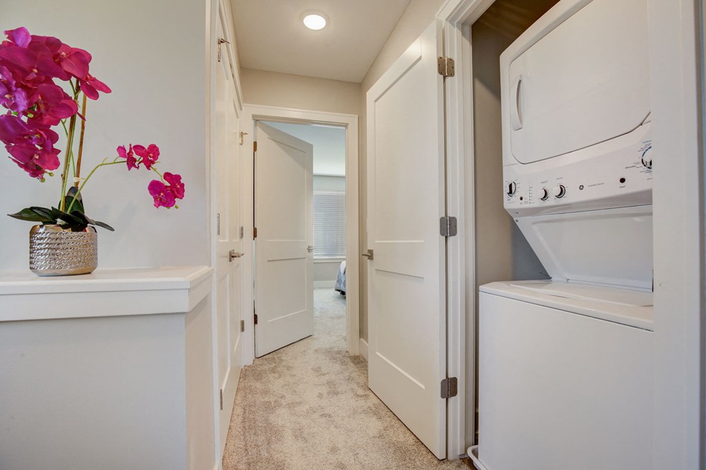 a laundry room with a washer and dryer and a door to a bathroom