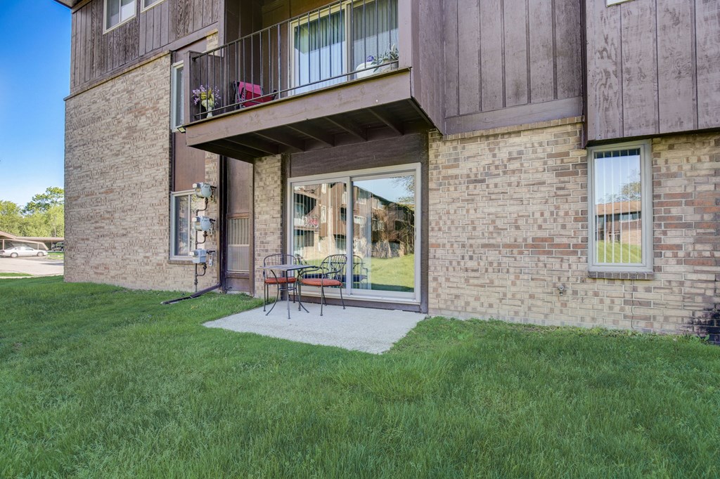 a patio in front of a brick building with a sliding glass door