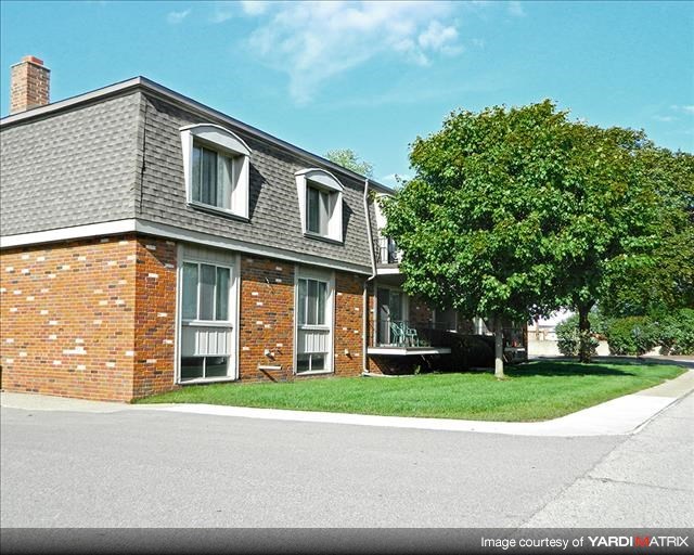 a brick house with a tree in the yard