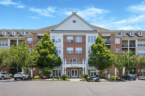 A large apartment complex with a parking lot in front.