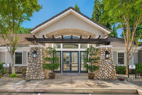 A modern house entrance with a stone pillar and a glass door.