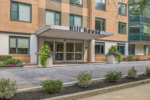 The front of a building called Hill House with a white awning.