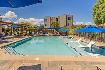 our resort style swimming pool with umbrellas and chairs at our hotel