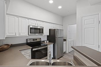 Fully-equipped and upgraded kitchens with wood-look flooring - Grand Centennial Apartments