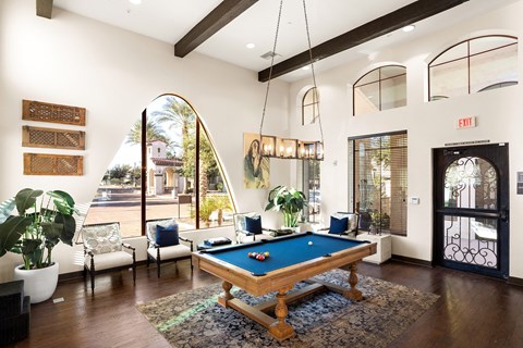 a living room with a pool table in the middle of it