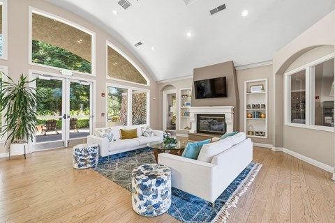 A living room with a white couch and a blue and white ottoman.