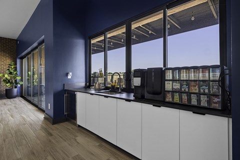 A kitchen with white cabinets and a dark blue wall.