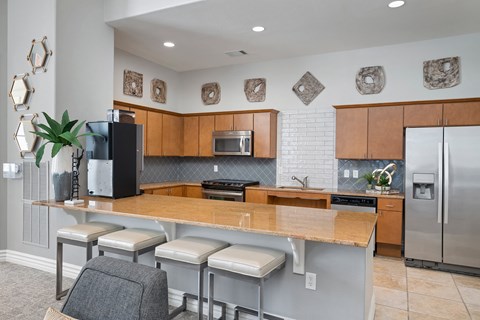a kitchen with a large island and a stainless steel refrigerator