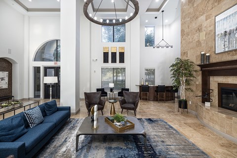 A living room with a blue couch and a fireplace.