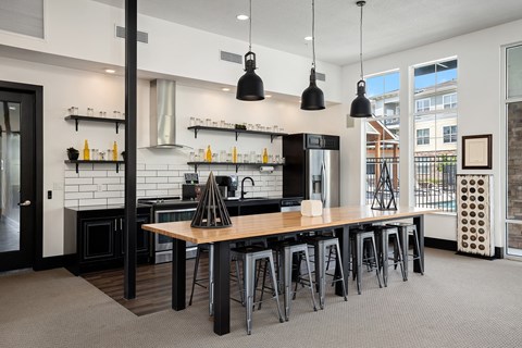 a large kitchen with a wooden table and bar stools