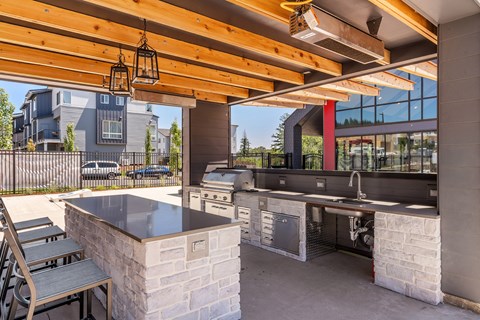the deck has an outdoor kitchen with a grill and a table