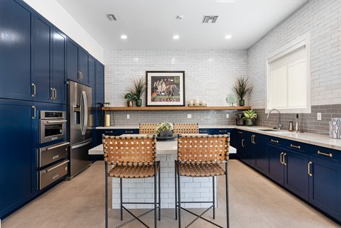 a kitchen with blue cabinets and a table with high chairs