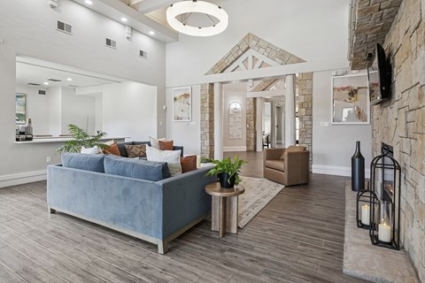 A living room with a blue couch and a stone wall.