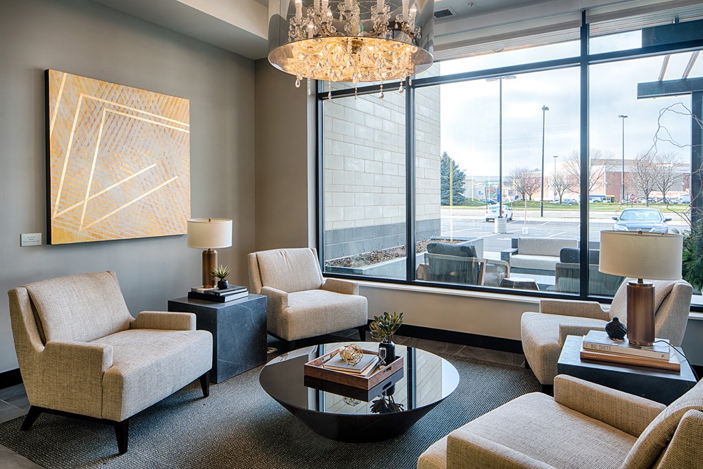 a living room with chairs and a table and a large window