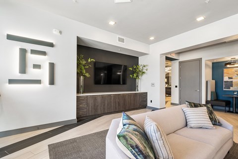 A modern living room with a large couch and a television.