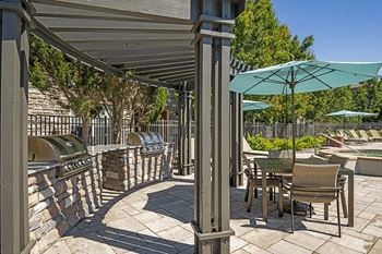 Outdoor patio with BBQ grill and dining tables - Acadia at Cornerstar Apartments