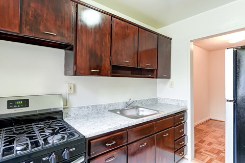 a kitchen with black appliances and wooden cabinets and a sink