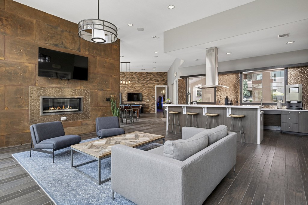 Resident clubhouse with tv above fireplace - First and Main Apartments