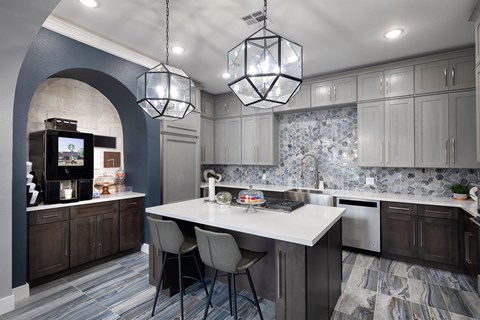 a kitchen with a large white island and gray cabinets