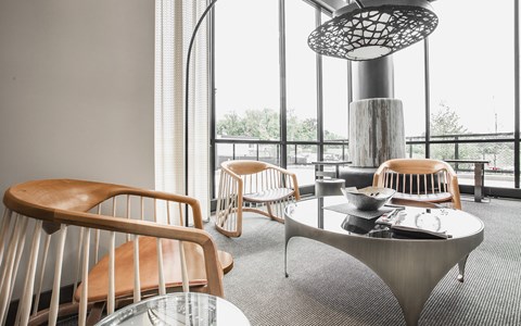 A room with a table and chairs and a hanging light fixture.