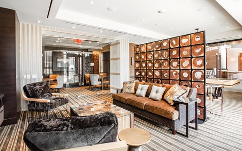 A modern living room with a large couch and a unique orange wall panel.