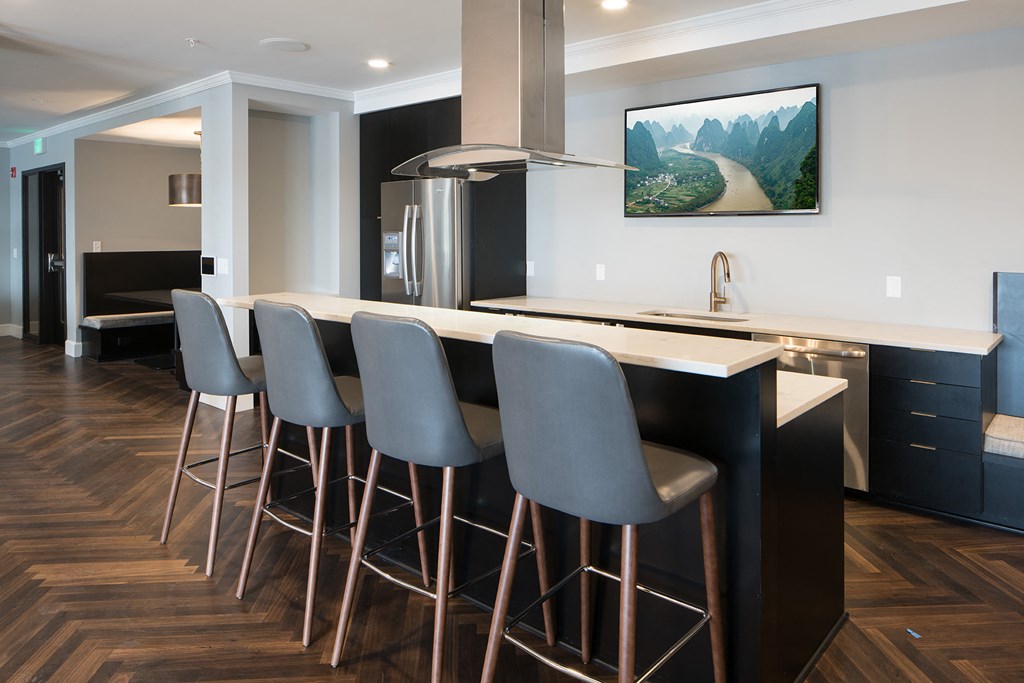 Resident clubhouse kitchen with fridge and bar seating - Onyx Edina