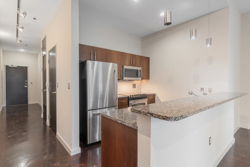 a kitchen with a granite counter top and a stainless steel refrigerator