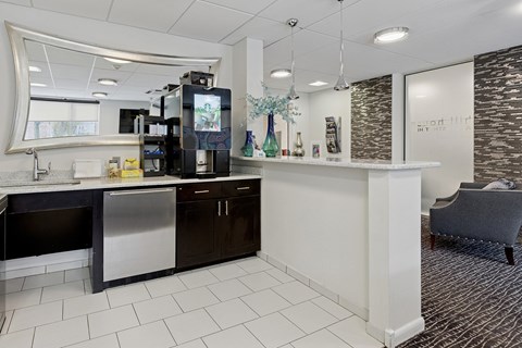 A modern kitchen with a white counter and black cabinets.