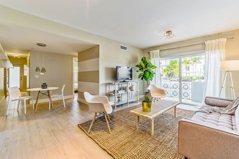 A living room with a couch, chairs, and a television.