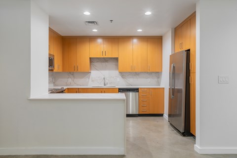 A kitchen with wooden cabinets and a refrigerator.