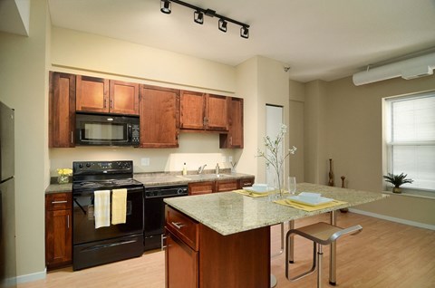a kitchen with black appliances and a granite counter top