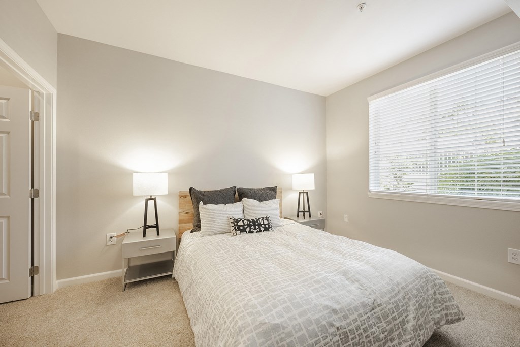 a bedroom with a bed and a large window