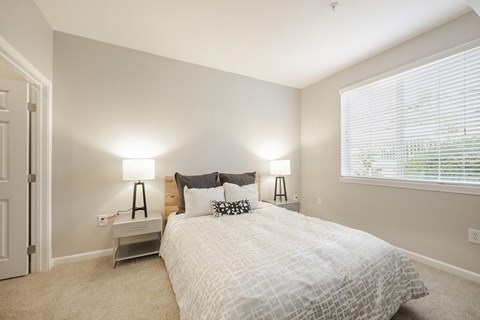 a bedroom with a bed and a large window