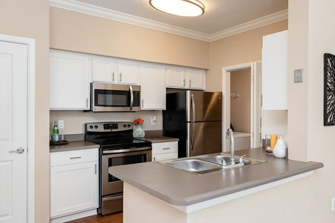 a kitchen with stainless steel appliances and white cabinets